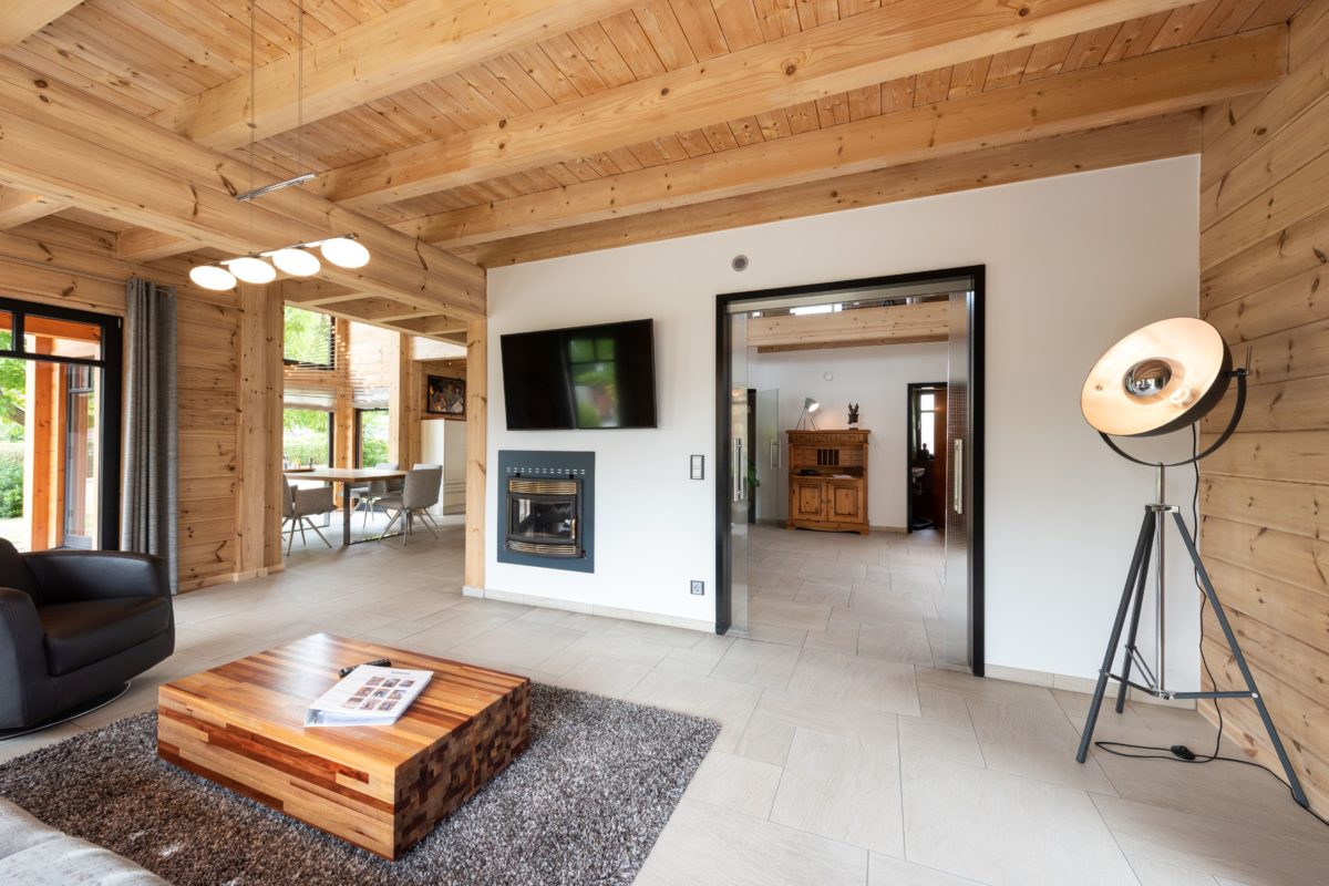 Musterhaus Hohenlohe - Ein Wohnzimmer mit Möbeln und einem Kamin - Interior Design Services