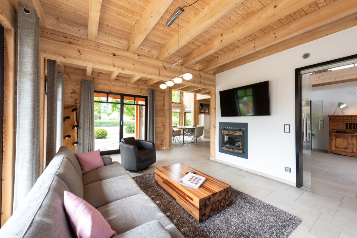 Musterhaus Hohenlohe - Ein Wohnzimmer mit Möbeln und einem großen Fenster - Interior Design Services