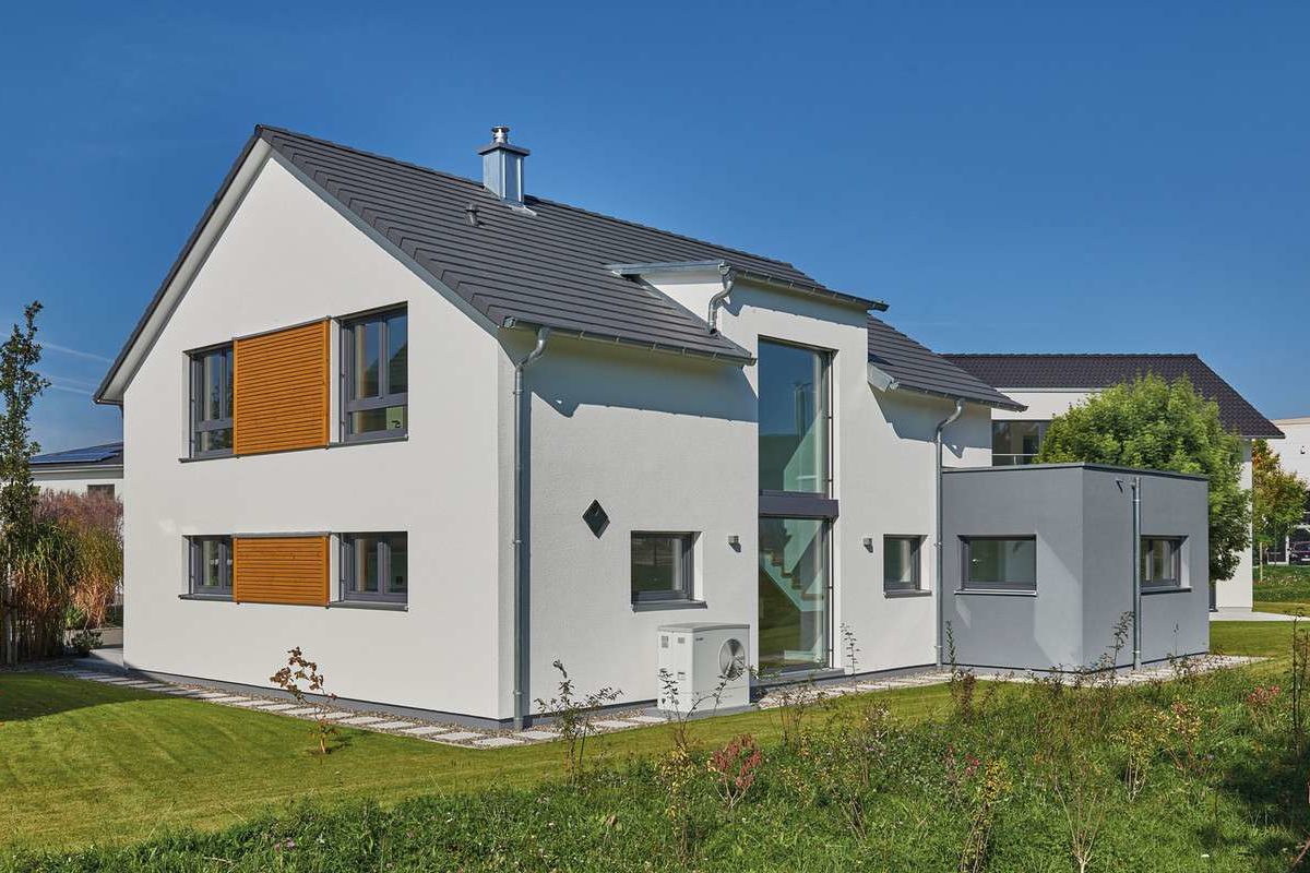 Musterhaus Günzburg - Eine große Wiese vor einem Haus - Fertighaus Weiss