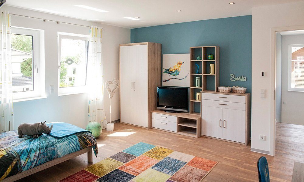 Musterhaus Bad Vilbel - Ein Wohnzimmer mit Möbeln und einem Flachbildfernseher - Bettrahmen