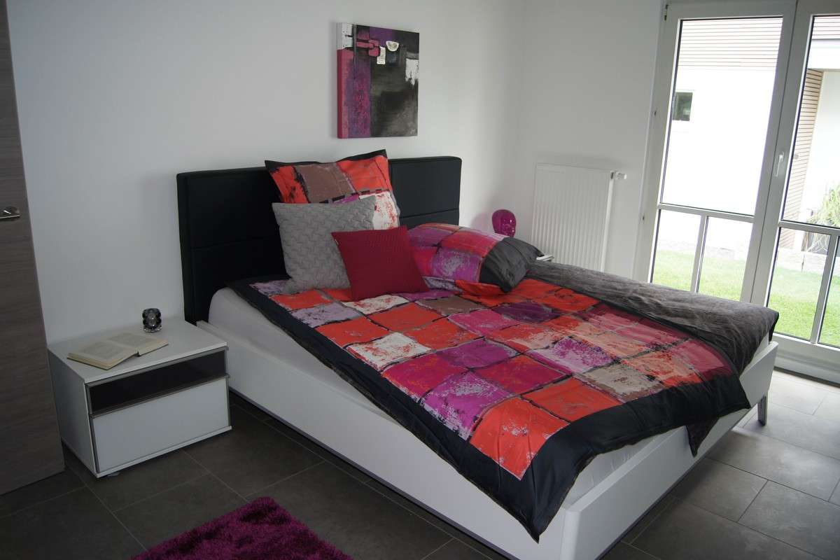Musterhaus Fellbach - Ein Schlafzimmer mit einem roten Teppich - Haus