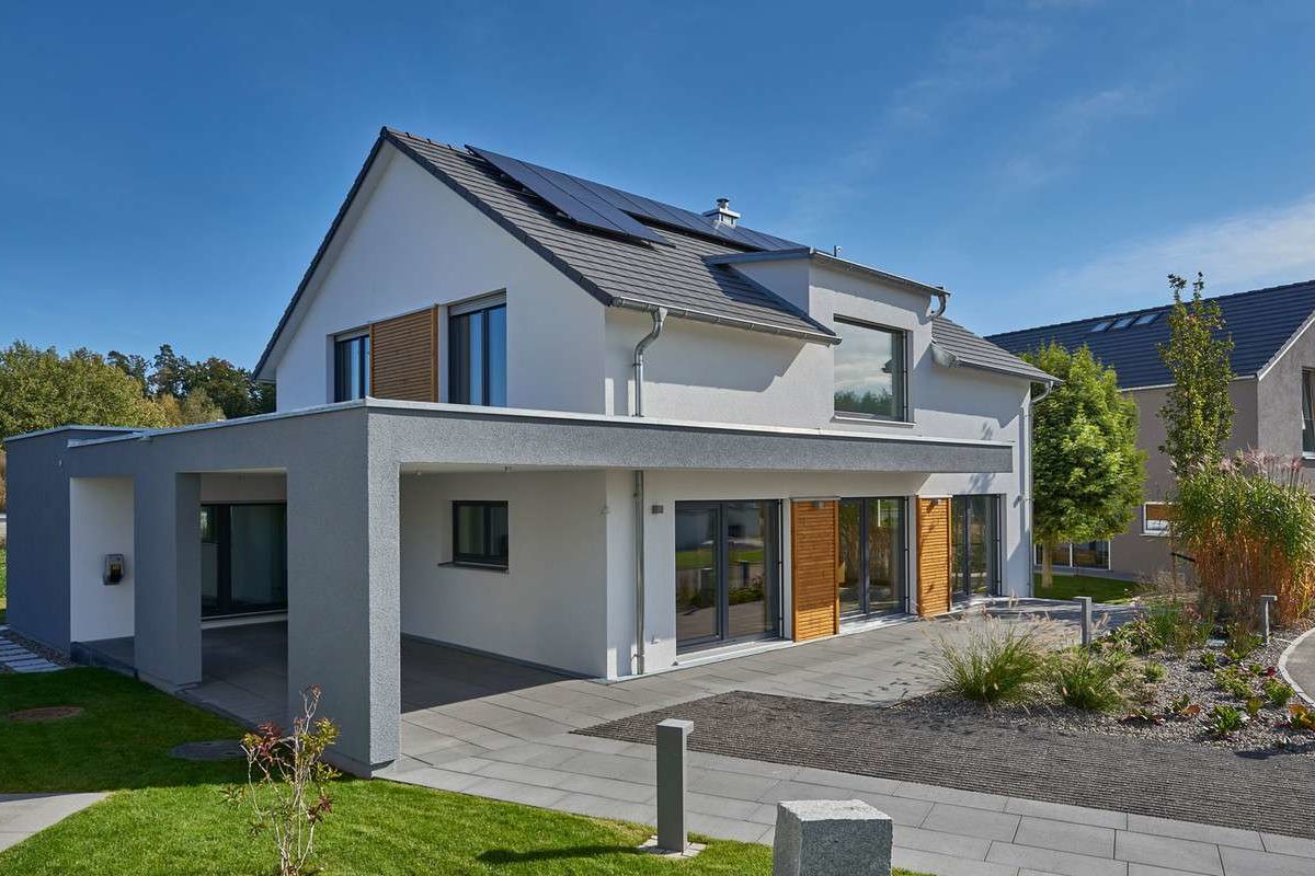 Musterhaus Günzburg - Ein großes Backsteingebäude mit Gras vor einem Haus - Fertighaus Weiss