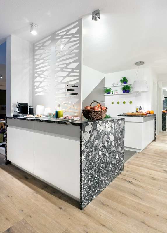 Musterhaus Köln - Eine Küche mit einer Insel mitten in einem Raum - Interior Design Services