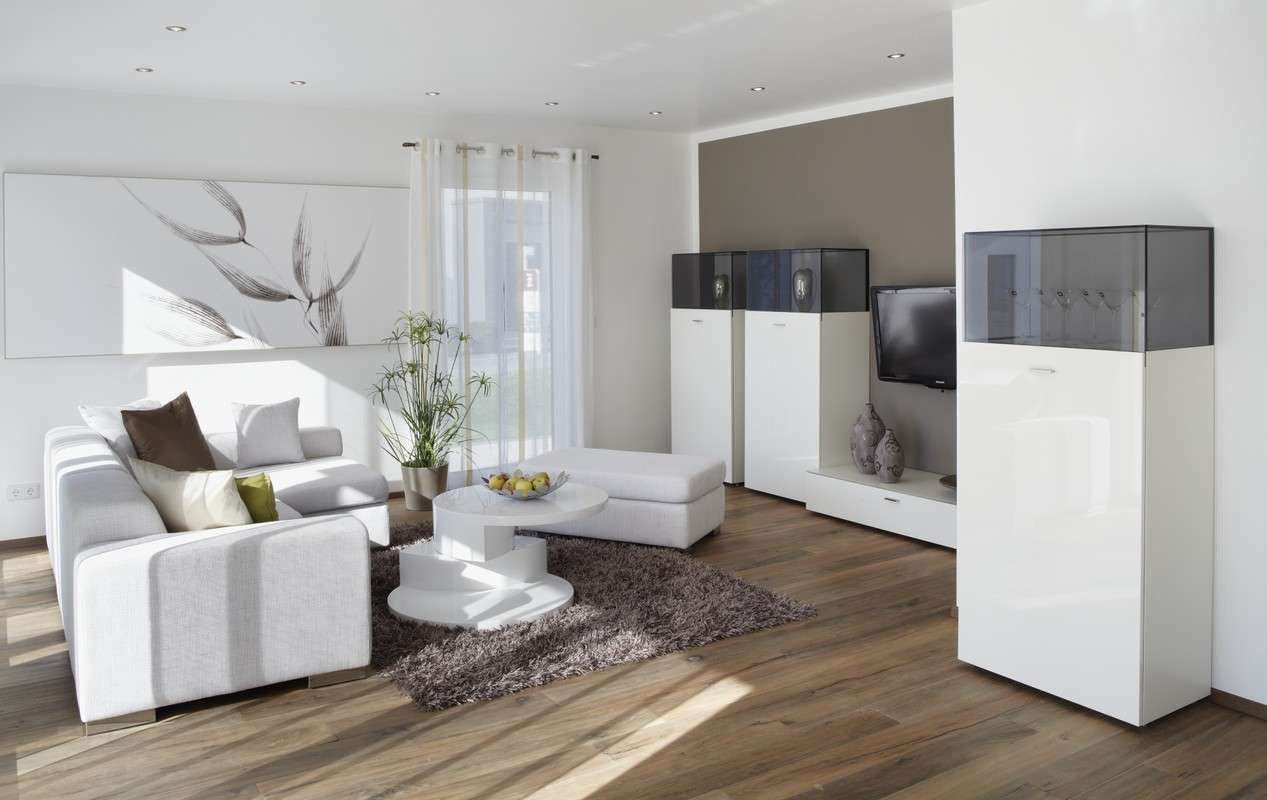 Musterhaus Avenio - Ein Wohnzimmer mit Möbeln und einem großen Fenster - Fußboden