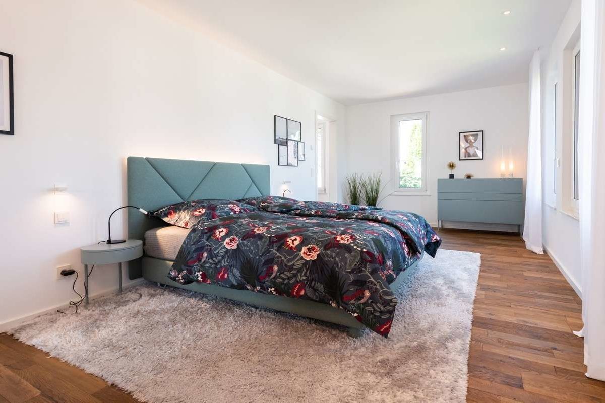 Musterhaus Victoria - Ein Schlafzimmer mit einem Bett in einem Raum - Schlafzimmer