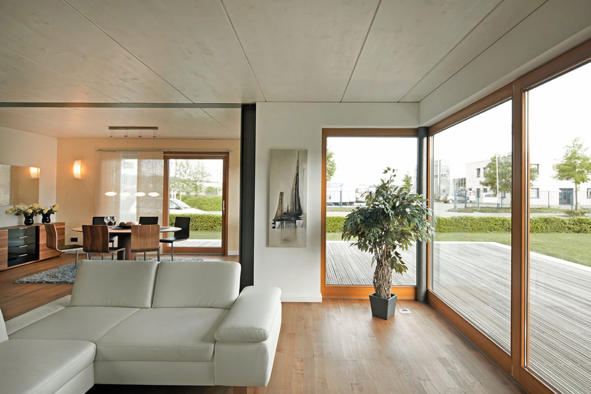 Musterhaus Kaarst - Ein Wohnzimmer mit Möbeln und einem großen Fenster - Schwimmendes glas