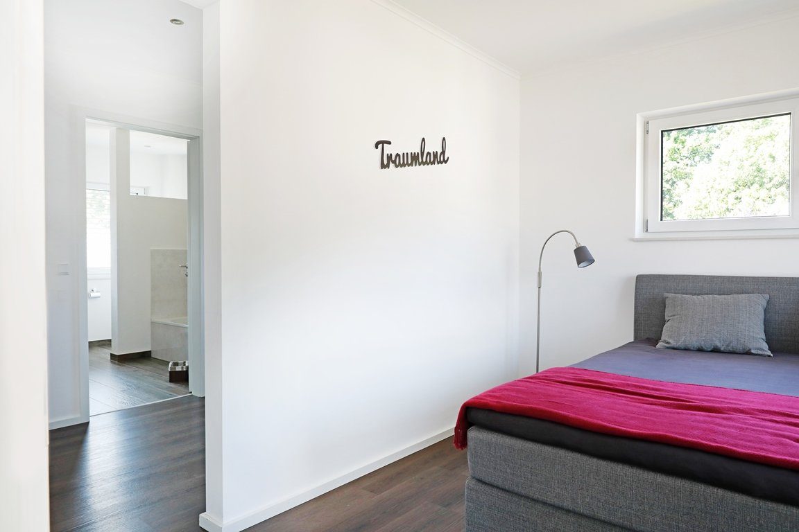 Stadtvilla 175 - Ein Schlafzimmer mit einem Bett in einem Raum - Haus zeigen