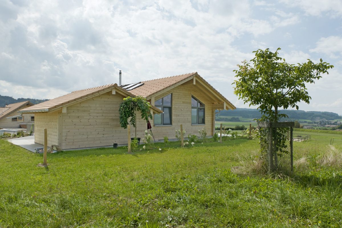 Holzhaus Sunnsite - Ein Haus mit einer Wiese - Haus