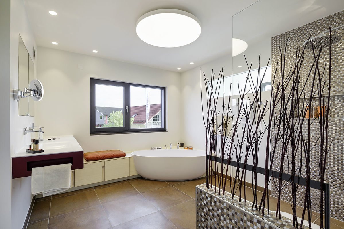 Musterhaus Fine - Eine große weiße Wanne neben einem Fenster - Musterhaus LUXHAUS | fine.