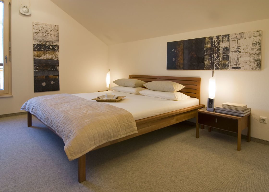 Design 168 - Ein Schlafzimmer mit einem Bett und einem Schreibtisch in einem Hotelzimmer - Holzhaus