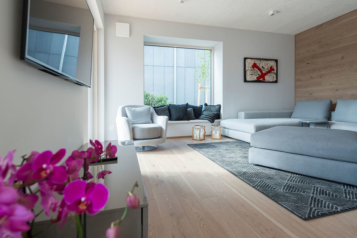 Griffner Classic München - Ein Wohnzimmer mit Möbeln und Blumenvase auf einem Tisch - GriffnerHaus AG