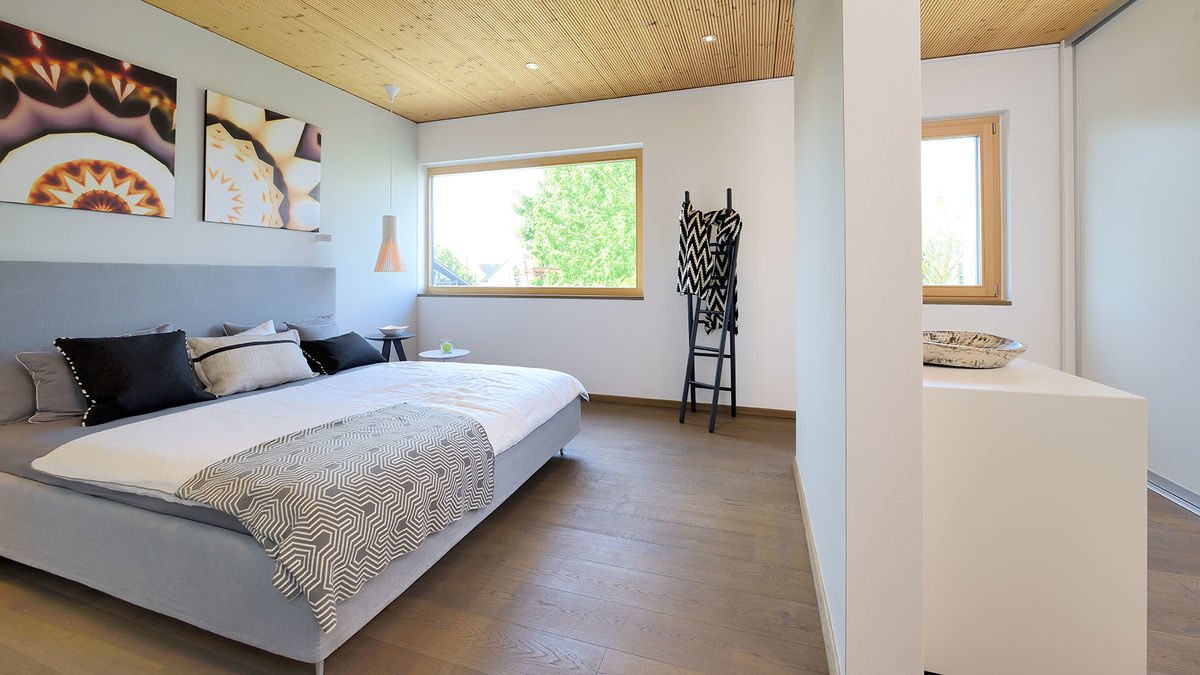 Musterhaus Poing - Ein Schlafzimmer mit einem Bett in einem Raum - Bauzentrum Poing