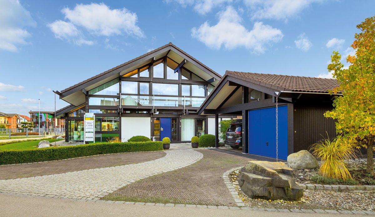 HUF HAUS Musterhaus München - Ein großes Backsteingebäude mit Gras vor einem Haus - Haus