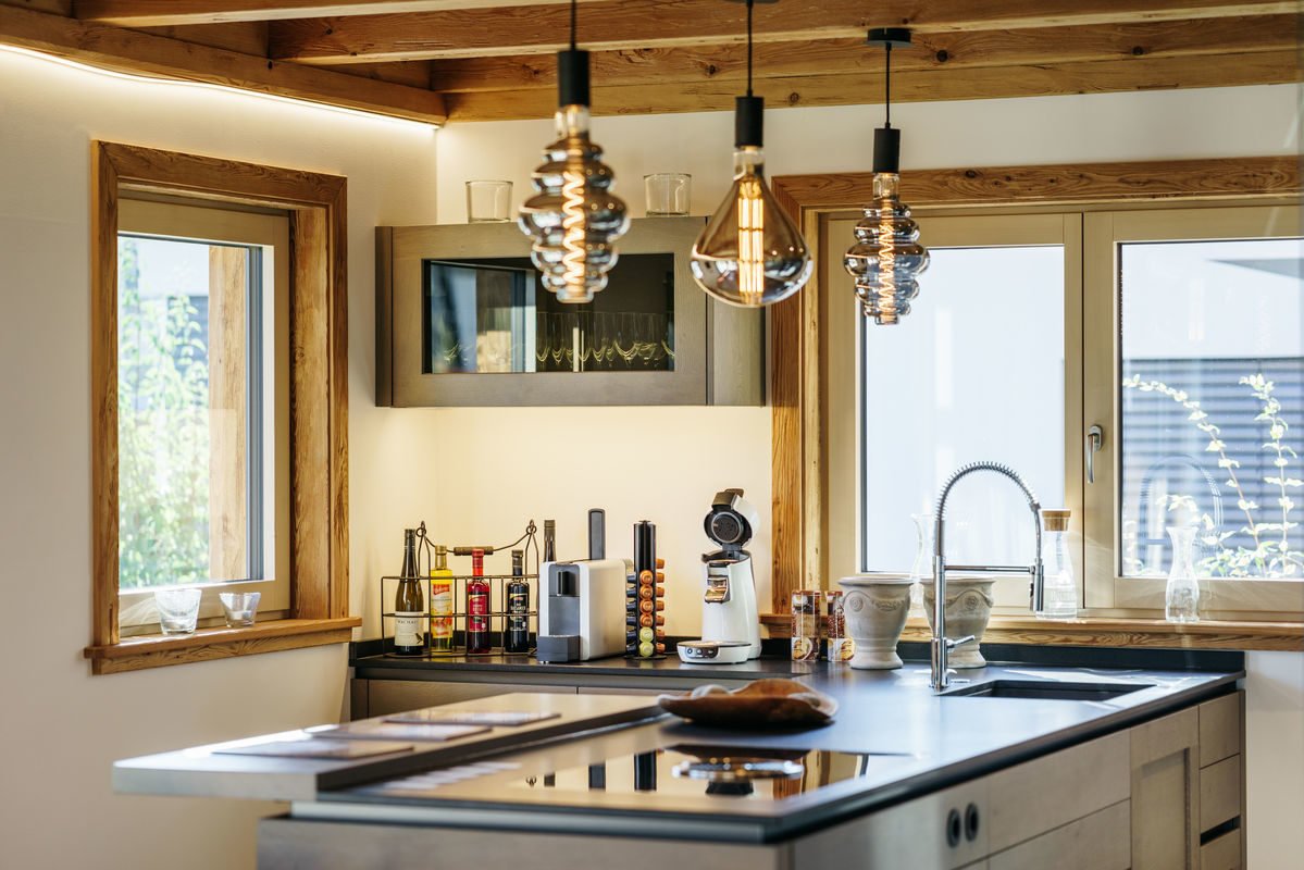 Musterhaus Poing - Eine küche mit waschbecken und fenster - Tiroler Holzhaus