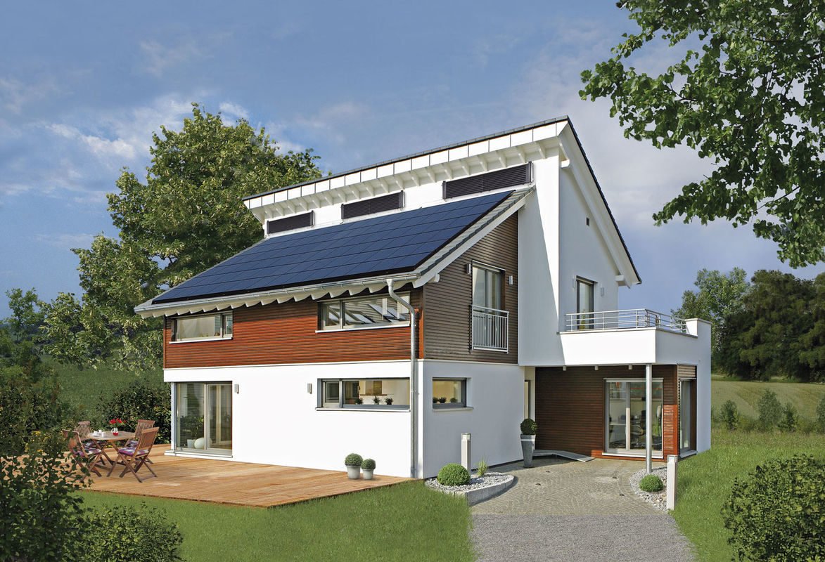 Plus-Energie-Haus Emotion - Ein großes Backsteingebäude mit Gras vor einem Haus - Haus