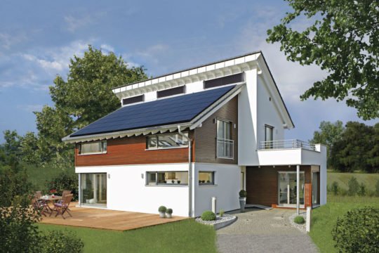 Plus-Energie-Haus Emotion - Ein großes Backsteingebäude mit Gras vor einem Haus - Haus