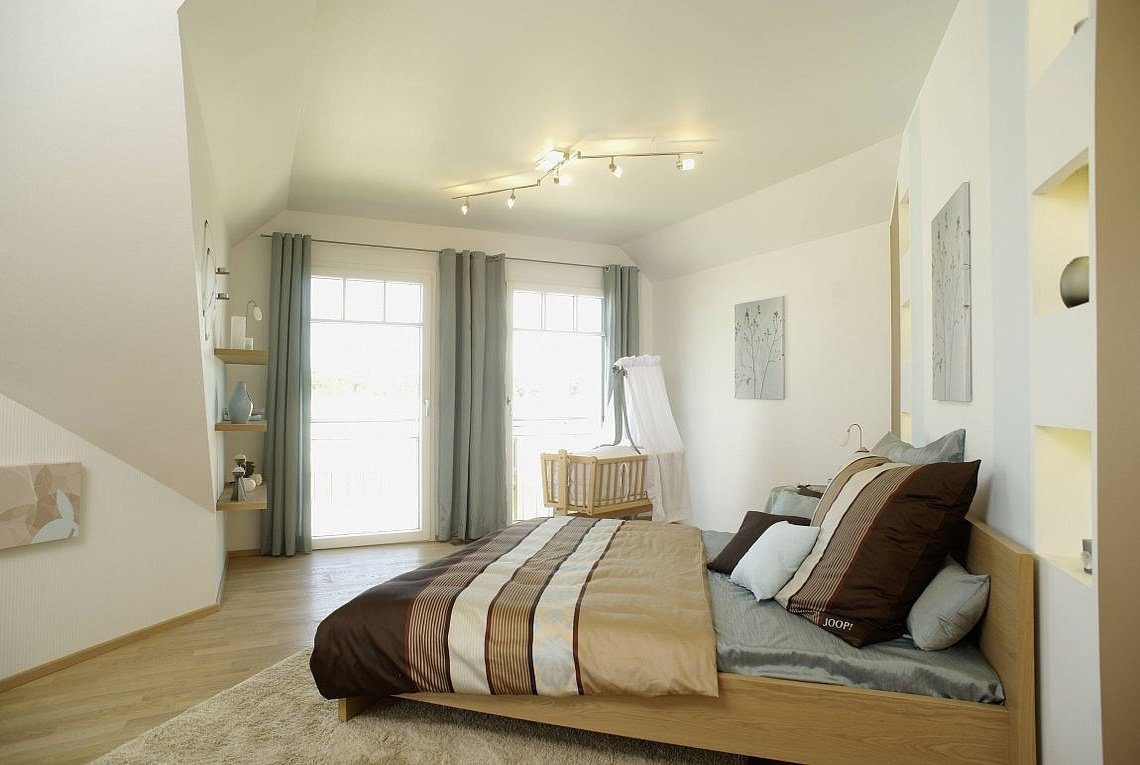 Musterhaus Barcelona - Ein Schlafzimmer mit einem großen Bett in einem Hotelzimmer - Rensch-Haus GmbH