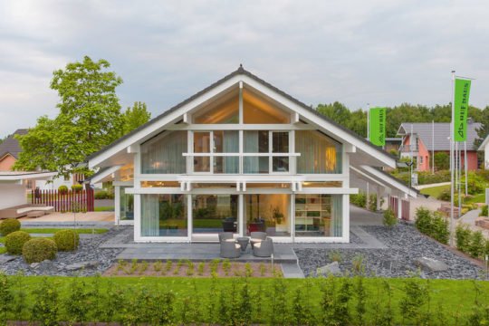 HUF HAUS Musterhaus Frankfurt - Ein Haus mit Bäumen im Hintergrund - Huf Haus