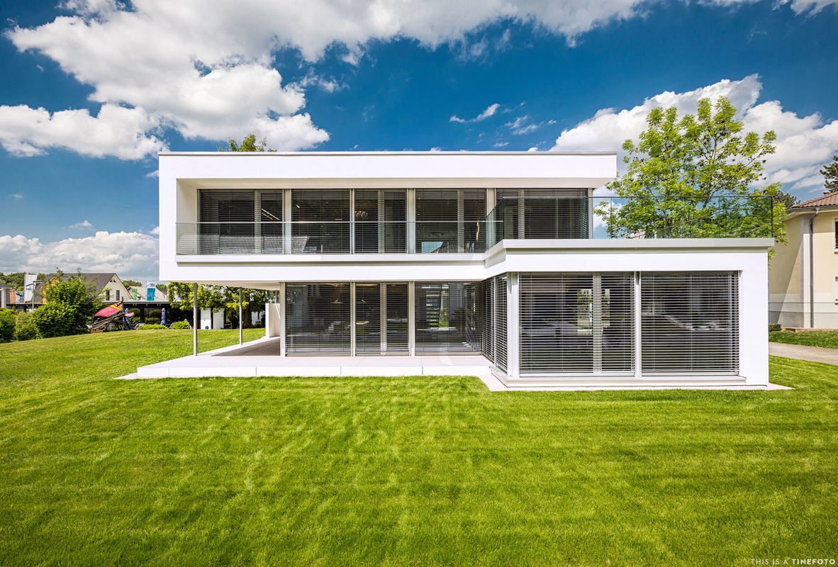 MusterHaus Bad Vilbel - Ein großes weißes Gebäude mit einer Wiese - Architektur - das Architekturhaus