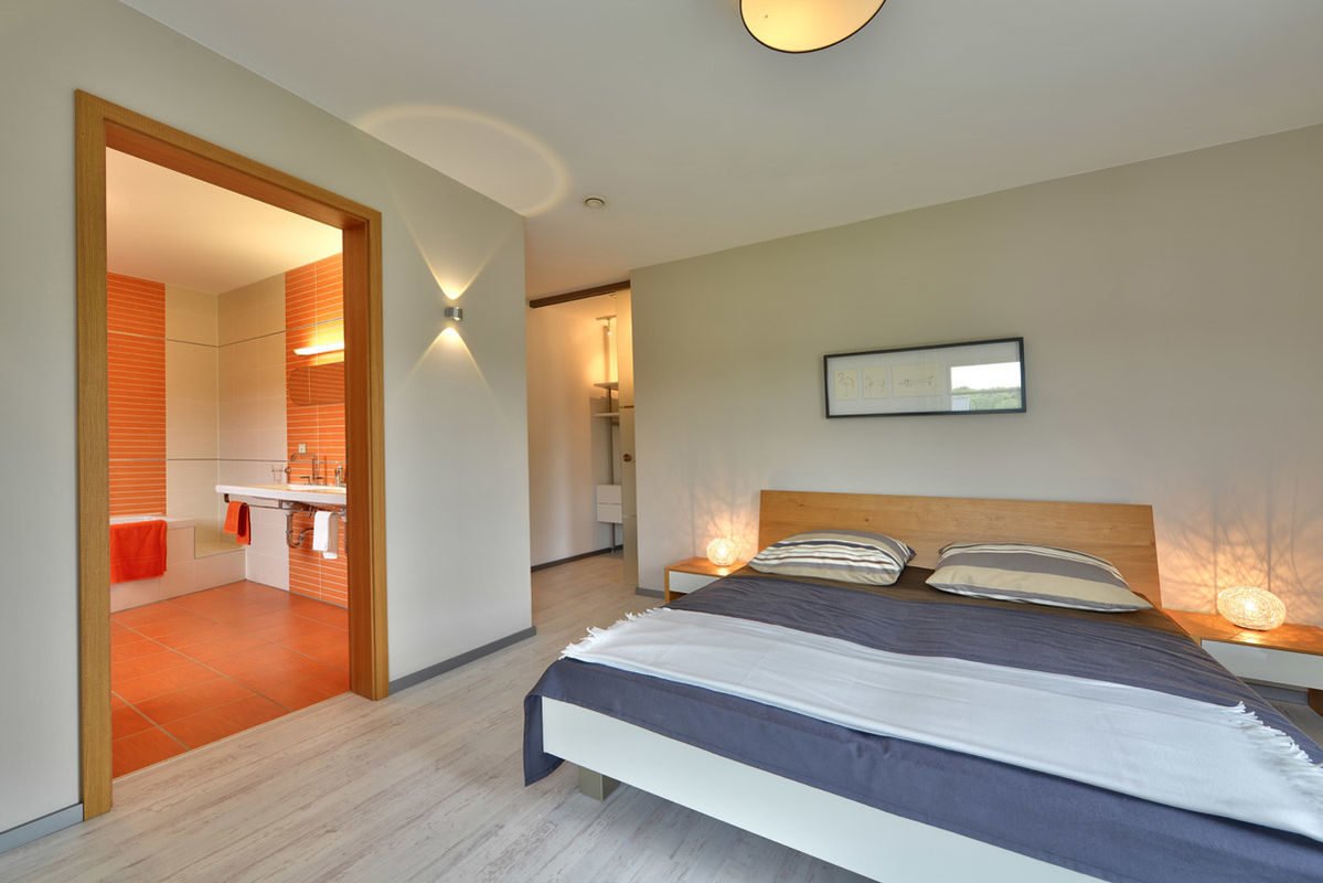 Florenzo - Ein Schlafzimmer mit einem Bett und einem Schreibtisch in einem Hotelzimmer - Büdenbender Hausbau GmbH