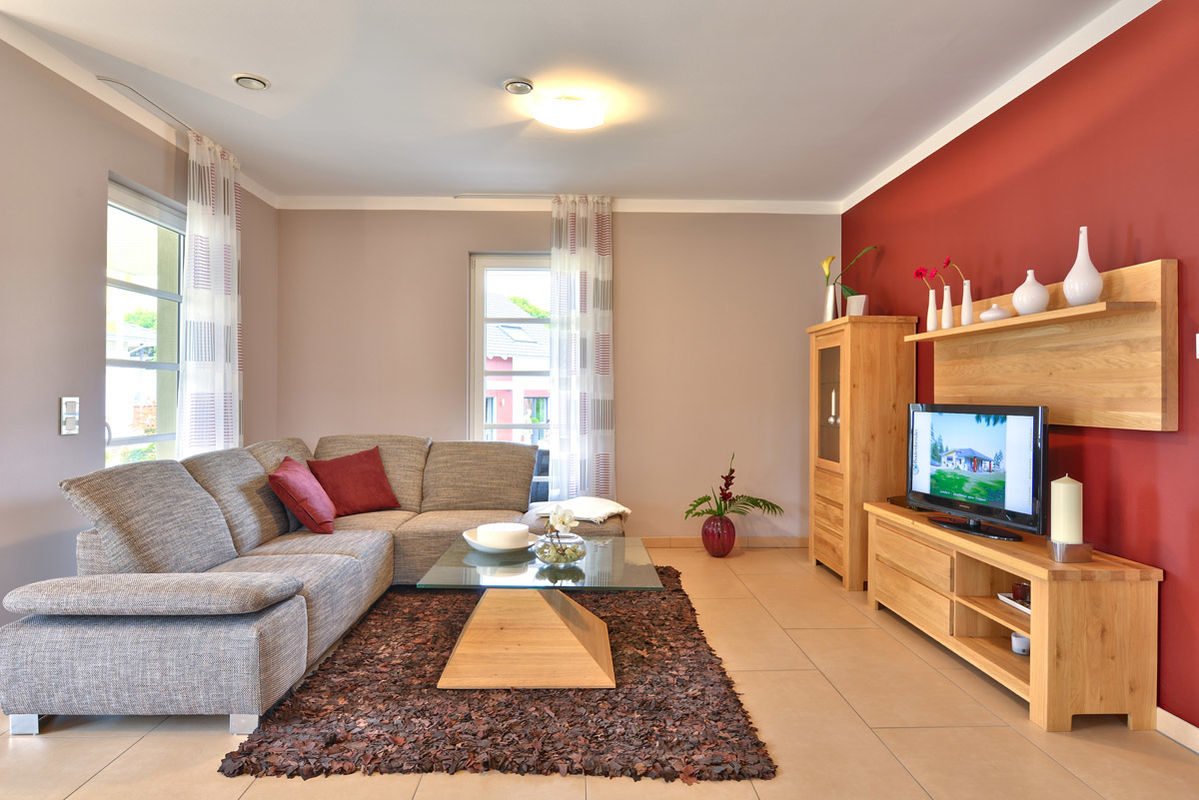 Florenzo - Ein Wohnzimmer mit Möbeln und einem Flachbildfernseher - Büdenbender Hausbau GmbH