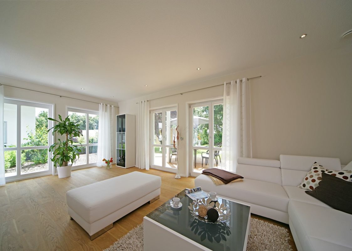 Keitel-Haus München - Ein Wohnzimmer mit Möbeln und einem großen Fenster - Interior Design Services