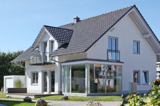 Musterhaus München - Eine große Wiese vor einem Haus - Lechner Massivhaus GmbH