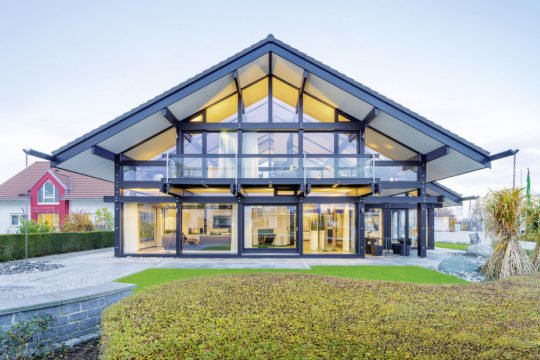 HUF HAUS Musterhaus München - Ein gelbes haus im hintergrund - Huf Haus