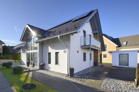 Musterhaus Poing-Grub - Ein großes Backsteingebäude mit Gras vor einem Haus - Haus