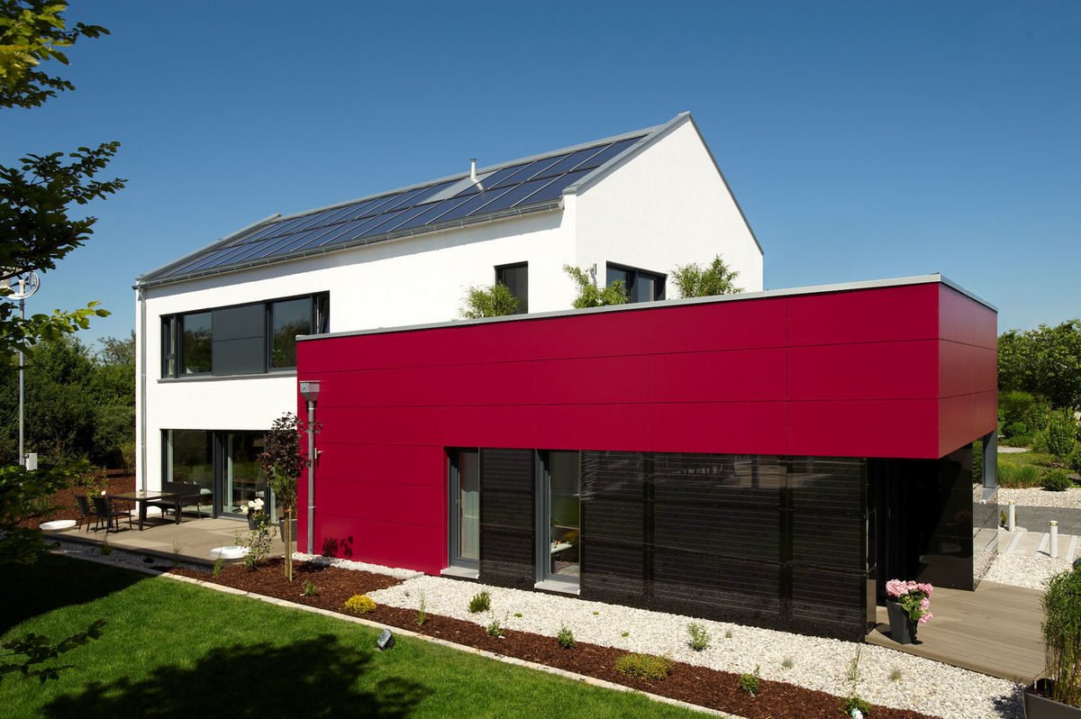 Energie-Plus-Haus Generation X - Ein großes Backsteingebäude mit Gras vor einem Haus - Haus