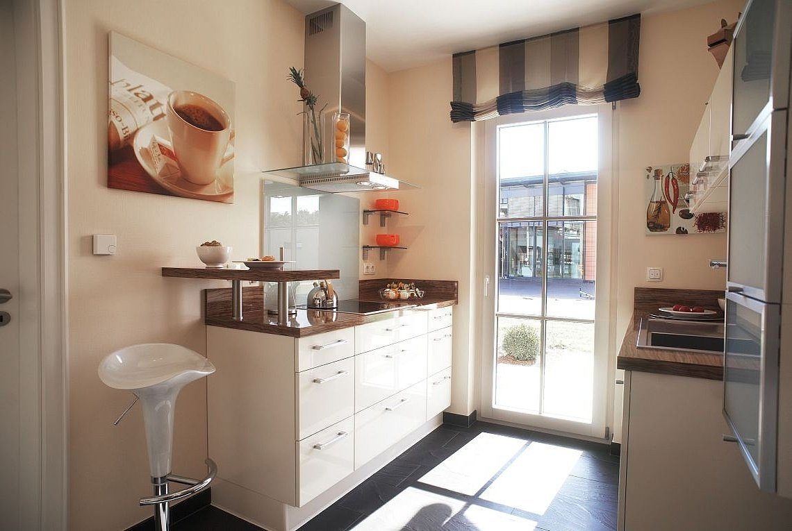 Musterhaus Madeira - Eine Küche mit einem Waschbecken und einem Spiegel in einem Raum - Haus
