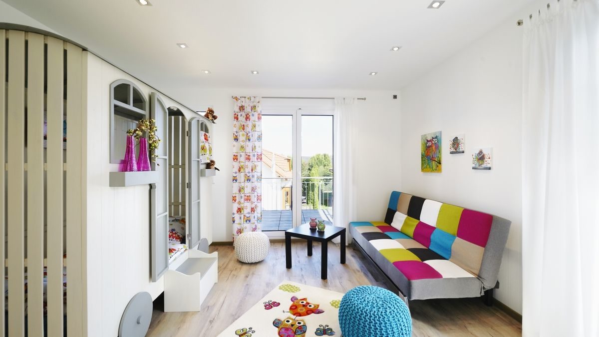 Musterhaus Montana - Ein farbenfrohes Wohnzimmer mit weißen Wänden - Interior Design Services
