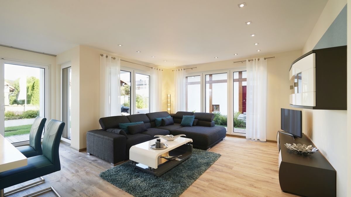 Musterhaus Montana - Ein Wohnzimmer mit Möbeln und einem Flachbildfernseher - Rensch-Haus GmbH