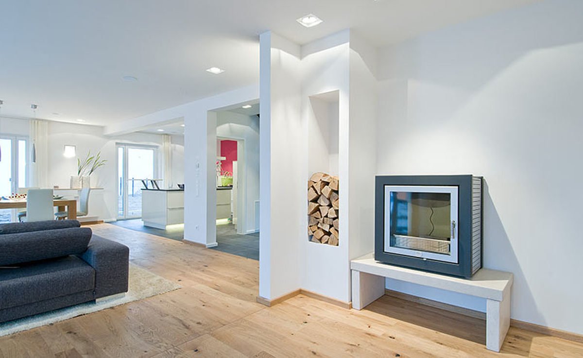 Musterhaus Hessdorf 169 - Ein Wohnzimmer mit Möbeln und einem großen Fenster - Interior Design Services