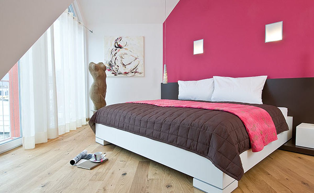Musterhaus Hessdorf 169 - Ein Schlafzimmer mit einem Bett und einem Schreibtisch in einem Raum - Bettrahmen