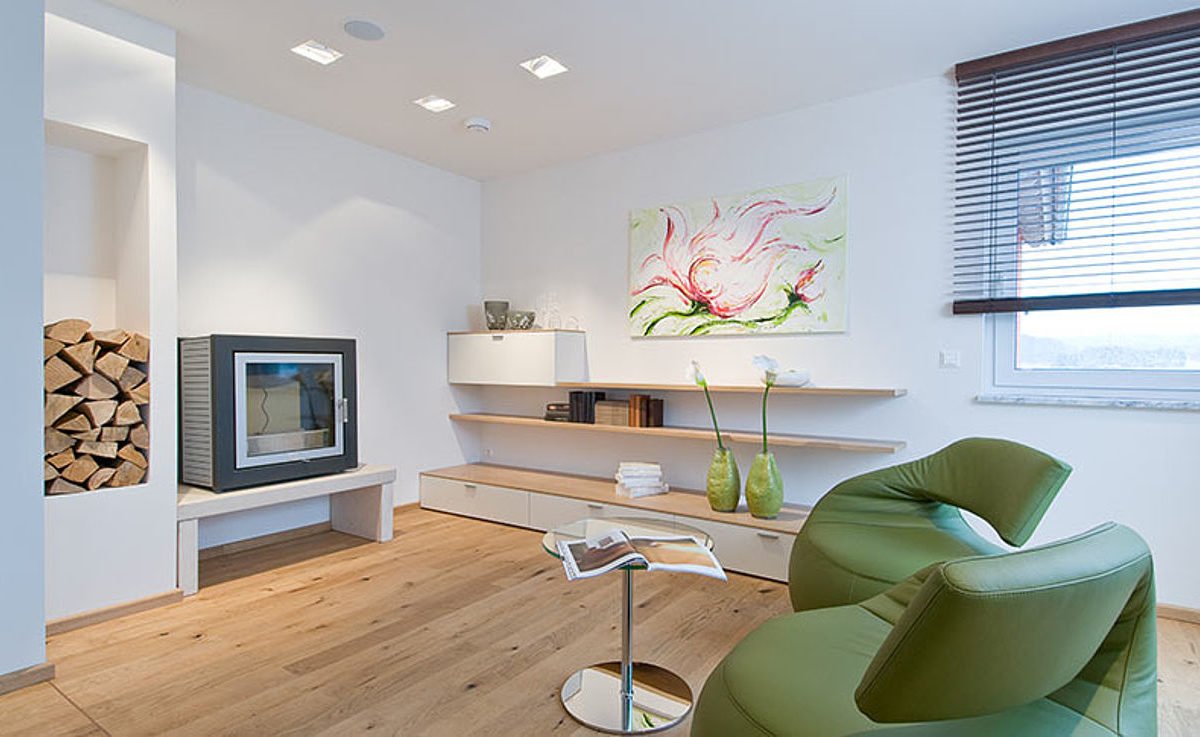 Musterhaus Hessdorf 169 - Ein Wohnzimmer mit Möbeln und einem Flachbildfernseher - Interior Design Services