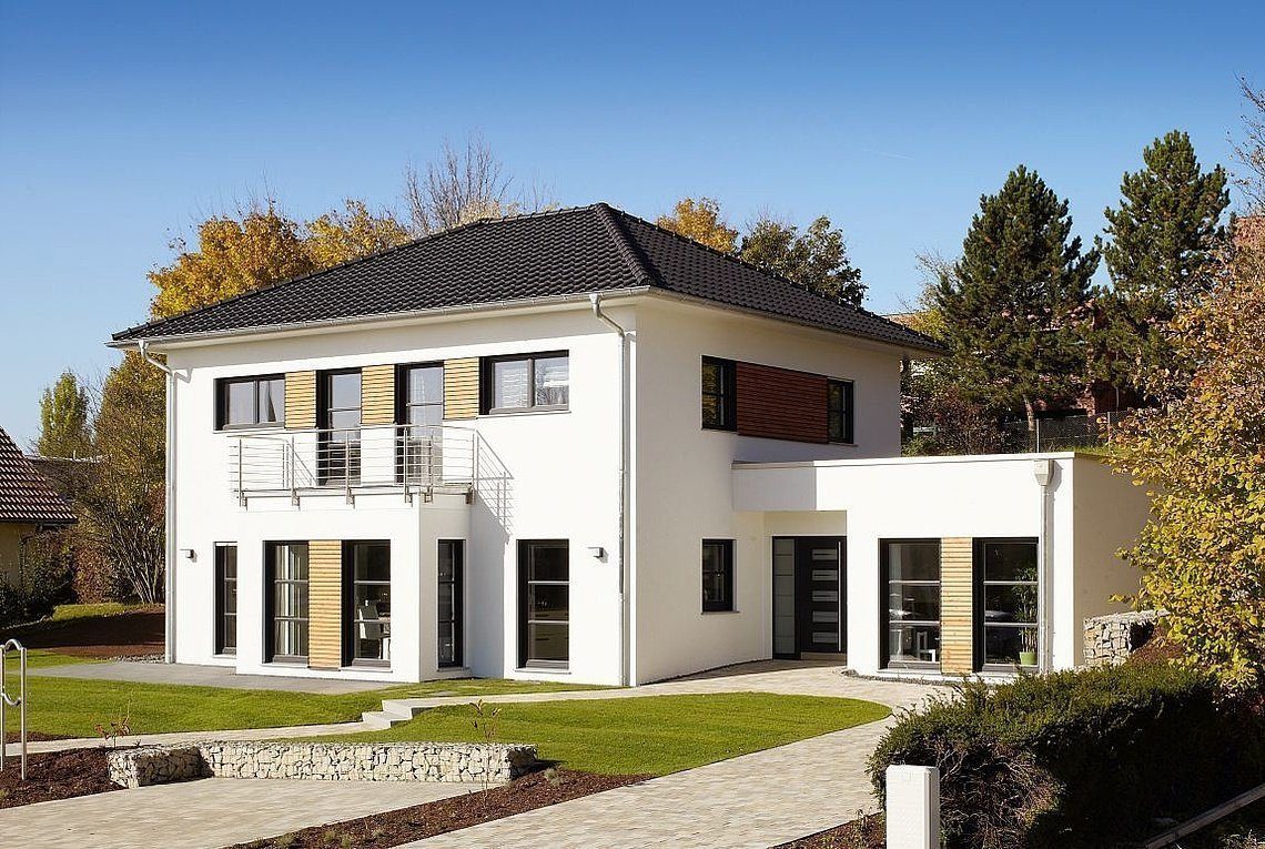 Musterhaus Orlando - Ein Haus mit Büschen vor einem Backsteingebäude - Rensch-Haus GmbH