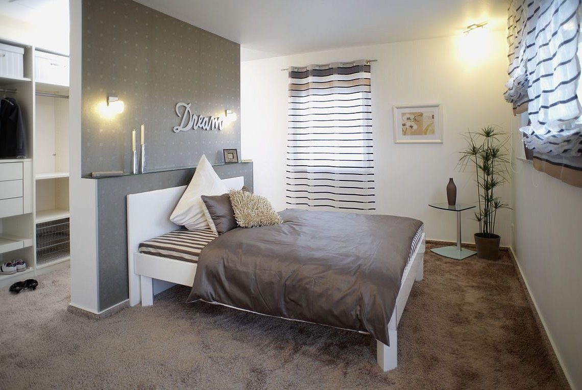 Musterhaus Orlando - Ein Schlafzimmer mit einem Bett und einem Schreibtisch in einem Raum - Haus