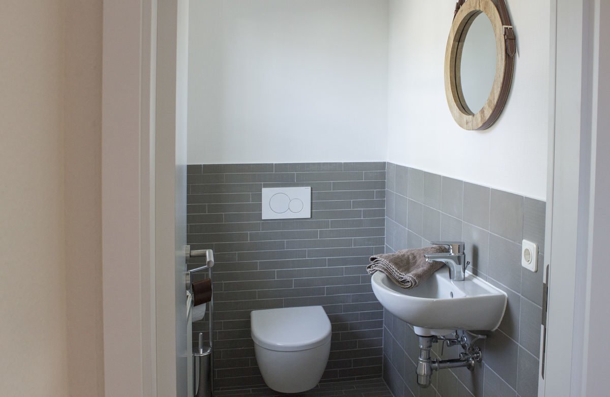 Musterhaus Bad Vilbel - Eine Toilette mit einem Waschbecken und einem Spiegel - Bad