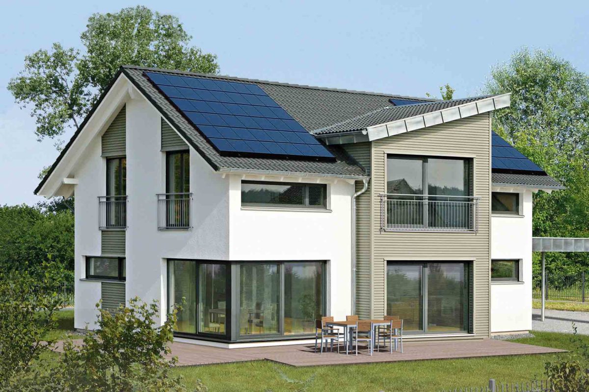 Musterhaus Erlangen - Ein großes Backsteingebäude mit Gras vor einem Haus - Fertighaus