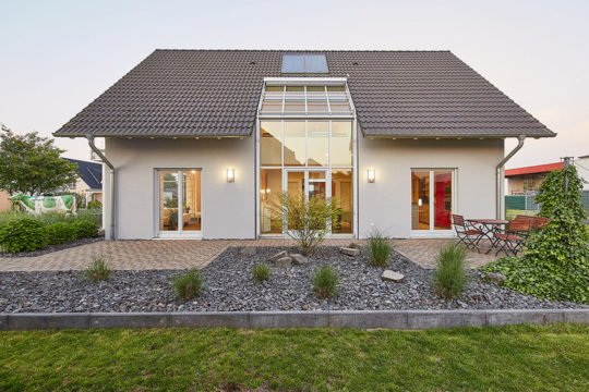 Musterhaus Evita - Ein Haus mit Bäumen im Hintergrund - Haus