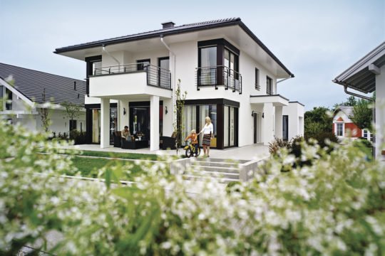 WeberHaus Individual - Ein Haus mit Bäumen im Hintergrund - WeberHaus