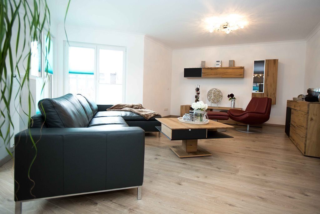 Musterhaus Poing - Ein Wohnzimmer mit Möbeln und einem Flachbildfernseher - Faust