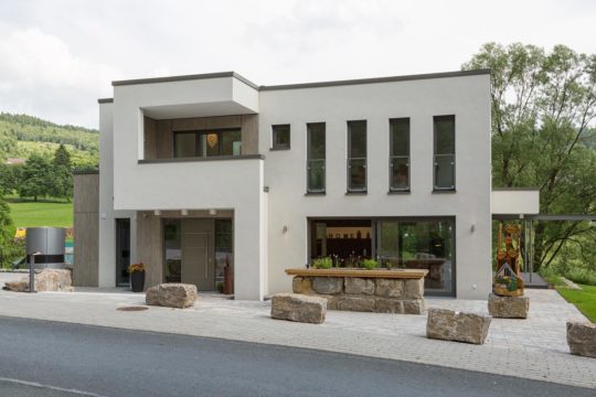 Musterhaus Satchmo Netphen-Hainchen - Eine Person, die mit einem Skateboard die Seite eines Gebäudes hinunterfährt - Büdenbender Hausbau Musterhaus Satchmo