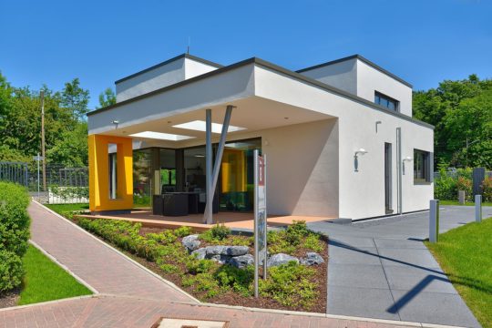 Musterhaus Valentino - Ein haus mit rasen vor einem gebäude - Fertighaus