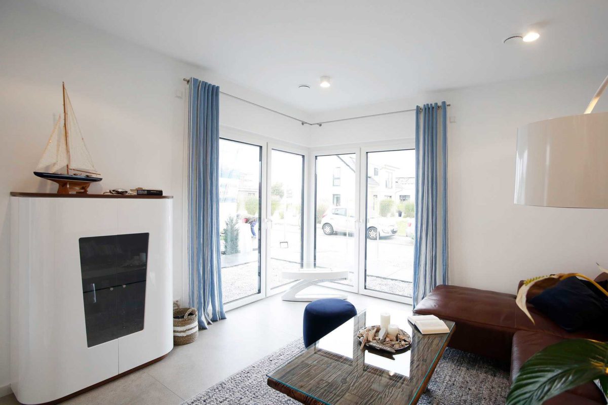 Musterhaus Werder - Ein Wohnzimmer mit Möbeln und einem großen Fenster - Interior Design Services