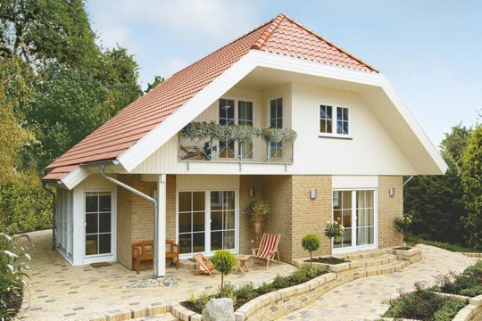 Kolding – das 1Liter-Haus! - Ein Haus mit Büschen vor einem Backsteingebäude - Danhaus GmbH