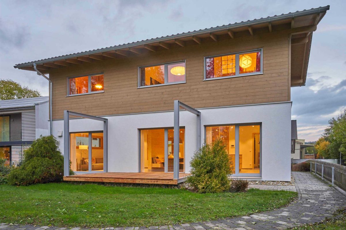 Musterhaus Casa Vita - Ein großes Backsteingebäude mit Gras vor einem Haus - Merklingen