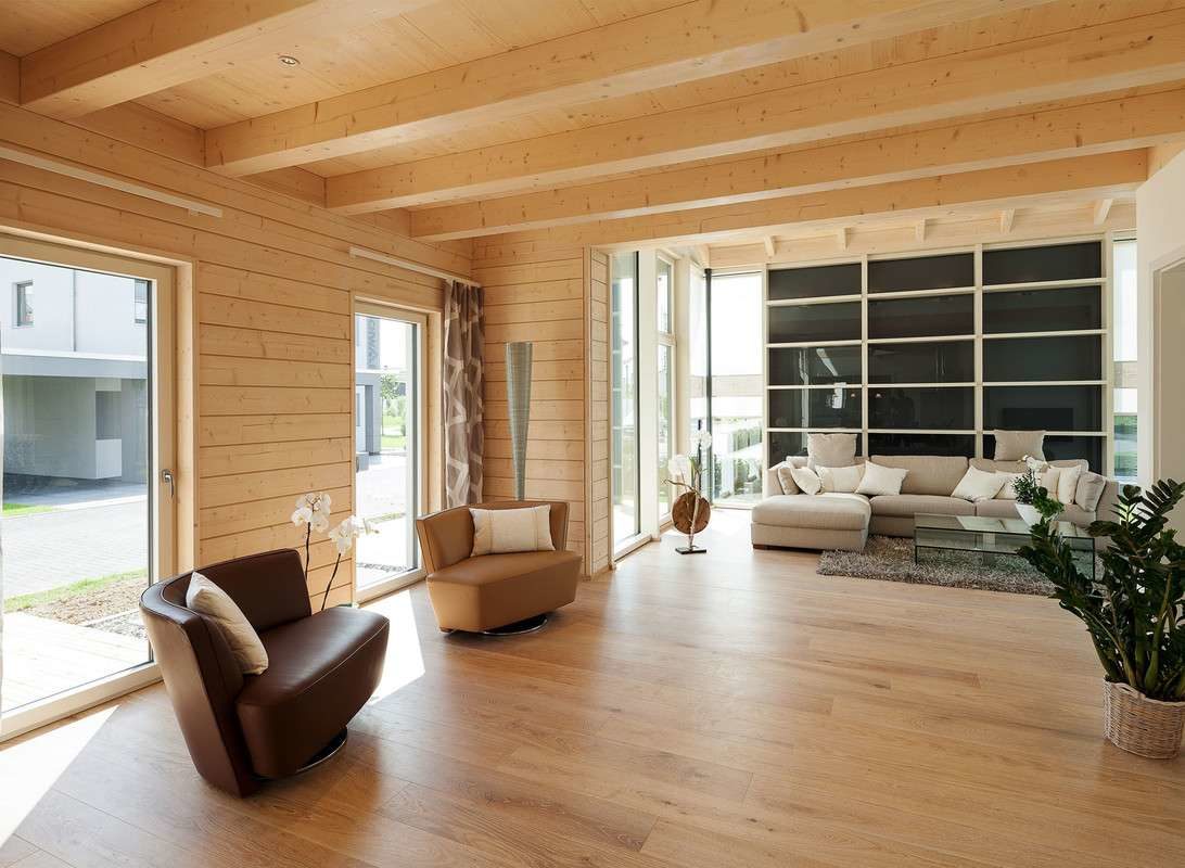 Musterhaus Traubeneiche - Ein Wohnzimmer mit Möbeln und einem großen Fenster - Schiffscontainer-Architektur