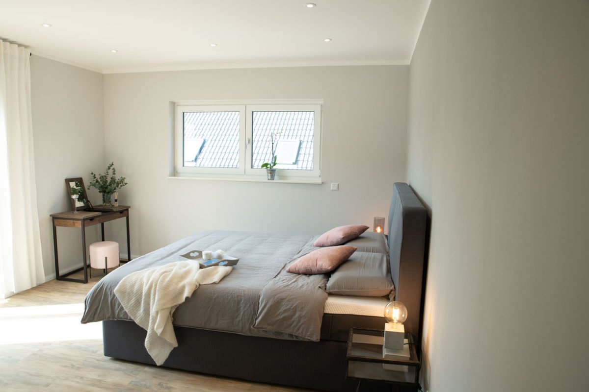 Musterhaus Flamingo - Ein Schlafzimmer mit einem Bett in einem Raum - Bettrahmen